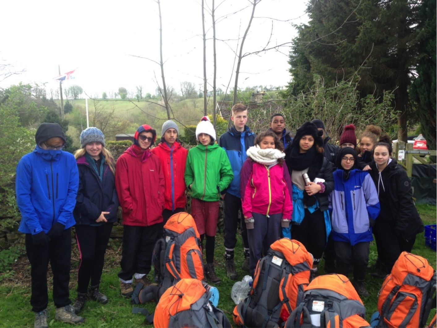 Duke of Edinburgh Group in their wet weather gear stand behind their rucksacks