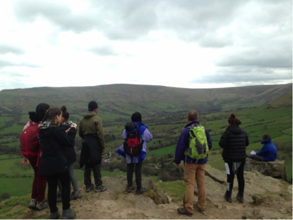 Group standing on peak, looking across a set of hills